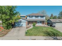 Charming two-story home featuring blue siding, brick accents, and a well-manicured front lawn at 6621 S Cherry Way, Centennial, CO 80121