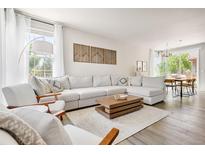 Bright, open living room with neutral tones, modern decor, and large sectional sofa at 14833 E Crestridge Dr, Centennial, CO 80015