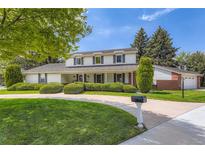 Charming two-story home with lush landscaping, circular driveway, and well-maintained lawn at 10130 E Powers Ave, Greenwood Village, CO 80111