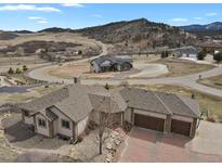 Expansive aerial view of the estate home with a three car garage, circular driveway, and mountain views at 5265 Club Ct, Larkspur, CO 80118