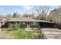 Brick ranch home with carport and fenced yard at 1242 Elder St, Denver, CO 80221