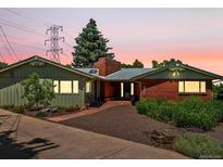 Charming single-story home featuring a brick facade, mature trees, and well-maintained landscaping at 10400 W 35Th Pl, Wheat Ridge, CO 80033