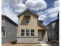 Charming two-story home featuring beige siding, stone accents, and well-placed windows at 2079 Generations Aly, Brighton, CO 80601
