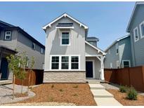 Charming two-story home with gray siding, stone accents, and a well-maintained front yard at 2079 Generations Aly, Brighton, CO 80601