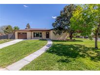 Charming one-story home with a well-manicured lawn, a concrete walkway, and a brown garage door at 190 Hemlock St, Broomfield, CO 80020