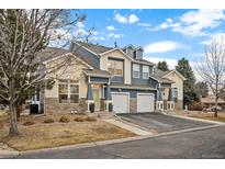 Attractive townhome featuring stone accents, attached garages and a well-manicured lawn with mature trees and shrubs at 4674 Flower St, Wheat Ridge, CO 80033