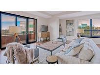 Bright living room with comfortable seating and access to a balcony at 4875 S Monaco St # 408, Denver, CO 80237