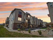 Modern townhome exterior featuring a multi-tone facade and professional landscaping at sunset at 11142 Bella Vita Dr, Broomfield, CO 80020