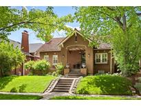 Charming single-Gathering home boasts an inviting front porch and beautifully landscaped front yard at 615 N Williams St, Denver, CO 80218