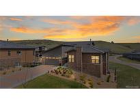 Beautiful home exterior with a well-manicured lawn and mountain views at sunset at 10869 Bluffside Dr, Lone Tree, CO 80124