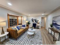 Bright living room with stylish furniture and hardwood floors at 8318 Benton Way, Arvada, CO 80003