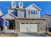 Charming two-story home featuring a stone facade, neutral siding, and a two-car garage at 26293 E Archer Ave, Aurora, CO 80018