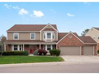 Charming two-story home with a well-manicured lawn, brick accents, and a three-car garage at 5454 S Everett Ct, Littleton, CO 80123