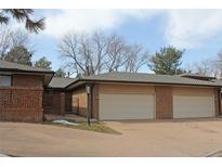 Brick home with attached garages and manicured lawn showcasing a traditional architectural design at 6150 W Mansfield Ave # 33, Denver, CO 80235