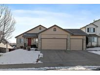 Beige two-story house with a three-car garage and snow-covered front yard at 12590 Prince Creek Dr, Parker, CO 80134