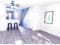 Bright living room with breakfast bar, sleek wood floors, and access to the upper level at 15475 E Louisiana Ave, Aurora, CO 80017