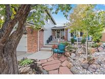 Charming home featuring a landscaped front yard, brick accents, and a cozy seating area at 87 Prairie Ridge Rd, Highlands Ranch, CO 80126