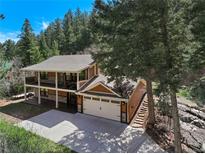 Stunning two-story home with a two car garage and a large driveway nestled amongst mature trees at 7134 Kiowa Rd, Larkspur, CO 80118
