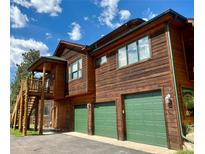 Charming home featuring a three-car garage, wood siding and a cozy front porch at 31755 Ponderosa Way, Evergreen, CO 80439