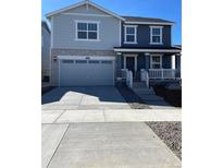 Two-story home featuring a two-car garage, covered porch, and a combination of stone and siding exterior at 21996 E 39Th Pl, Aurora, CO 80019