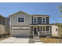 Charming two-story home featuring a covered porch, two-car garage, and nicely landscaped front yard at 21996 E 39Th Pl, Aurora, CO 80019
