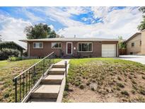 Charming single-story brick home featuring an attached garage and a well-manicured front yard with stairs at 2939 S Zurich Ct, Denver, CO 80236
