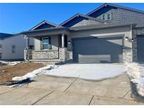 New construction home with gray siding, stone accents, and a two-car garage at 3441 N Denali St, Aurora, CO 80019