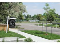 Sign displays 'Stunning Lake Views', and 'Expansive Roof Deck' near a home on a street with green grass and trees at 1647 N Osceola St, Denver, CO 80204