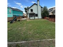 Expansive backyard featuring a well-maintained lawn, play structure, and partial fencing for privacy at 4362 Denmark Ct, Denver, CO 80239