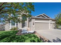Charming two-story home featuring a three-car garage and stone accents, set against a clear blue sky at 8700 Ehler Pkwy, Brighton, CO 80602