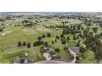 Expansive aerial view shows a home surrounded by lush greenery, trees, and vast open spaces at 12189 N Boot Hill Dr, Parker, CO 80138