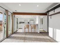 Bright living room featuring a breakfast bar with barstools and sliding glass doors to let light in at 4899 S Dudley St # 3, Littleton, CO 80123