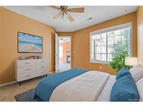 Comfortable bedroom with a white dresser, a television with beach images, and a bright window at 13782 E Lehigh Ave # H, Aurora, CO 80014