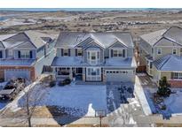 Charming two-story home with a well-manicured front yard dusted with snow at 15972 E Tall Timber Ln, Parker, CO 80134