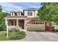 Charming two-story home featuring a brick facade, a cozy front porch, and a spacious two-car garage at 3109 S Jebel Way, Aurora, CO 80013