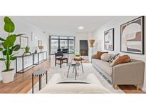 Bright living room with hardwood floors, modern furniture, and city views at 1777 Larimer St # 2209, Denver, CO 80202