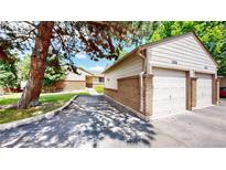 View of the exterior with a multi-car garage and a brick wall along the driveway at 1006 Homestake Dr # 1D, Golden, CO 80401