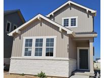 Charming two-story home featuring a stone base and vertical siding under a blue sky at 2102 Wagon Wheel Aly, Brighton, CO 80601