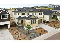 Inviting two-story home featuring a covered porch, landscaped yard, and a two-car garage at 3370 Backdrop Ct, Castle Rock, CO 80108