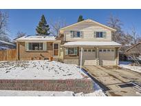 Brick house with two-car garage and snow-covered yard at 9235 Quitman St, Westminster, CO 80031