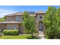 Elegant two-story home featuring a stone facade, tile roof, and lush landscaping at 14325 N Santa Fe St, Broomfield, CO 80023