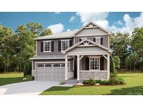 Charming two-story home featuring a covered front porch and a two-car garage with beautiful lawn and landscaping at 1301 Rock Cliff Ave, Erie, CO 80516