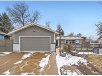 Charming gray house featuring an attached garage and inviting front yard at 7082 W 68Th Pl, Arvada, CO 80003