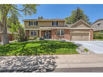 Charming two-story home with a well-manicured lawn and brick accents at 7573 S Saulsbury Ct, Littleton, CO 80128