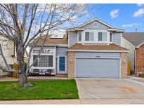Charming two-story home with a well-manicured lawn, a brick-accented garage, and a cozy front porch at 2529 S Truckee Way, Aurora, CO 80013