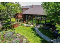 Beautiful home exterior featuring a well-manicured lawn and unique sunroom with expansive windows and charming landscaping at 559 E 2Nd Ave, Castle Rock, CO 80108