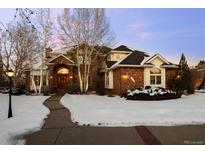 Brick two-story home with a snow-covered front yard and walkway at 7172 Waterford Ct, Niwot, CO 80503