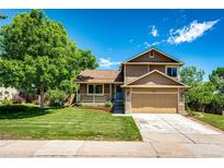 Charming two-story home with a well-manicured lawn, a covered porch, and a two-car garage at 19706 E Bellewood Dr, Centennial, CO 80015