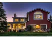 Charming home featuring a covered porch, well-manicured lawn, and a mix of siding and stone accents at 25779 E Jamison Cir, Aurora, CO 80016