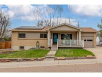 Charming single-story home featuring solar panels, a well-kept lawn, and inviting front porch at 6905 Nelson St, Arvada, CO 80004